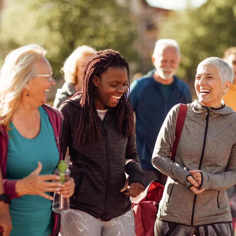 A group of mixed-age people laughing while walking.
