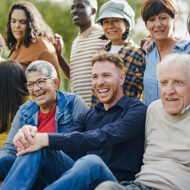 A group of smiling people sitting outside.